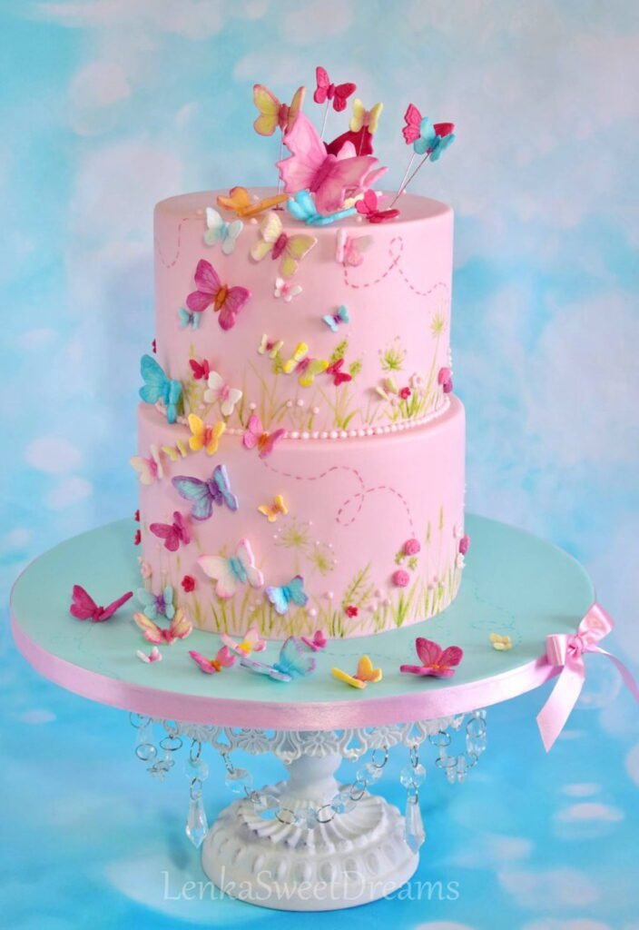 Two-tier butterfly wedding cake with cascading butterflies and sugar flowers