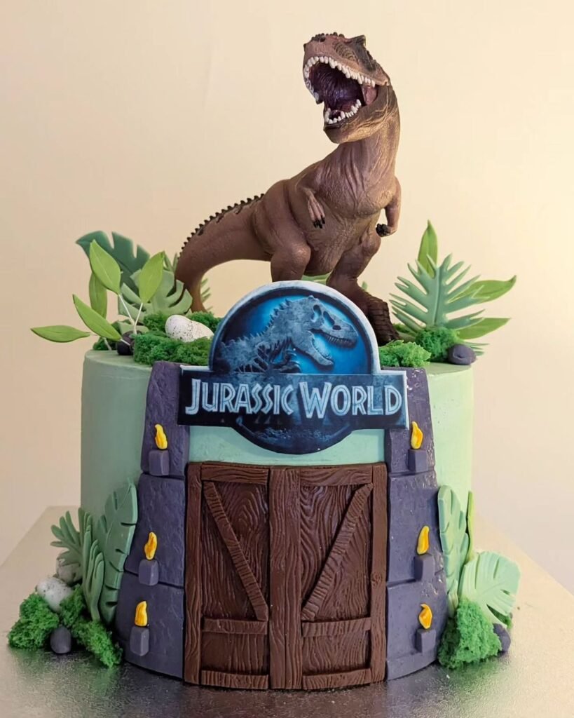 Jurassic Park theme cake featuring gate and dinosaurs – dinosaur cake design ideas